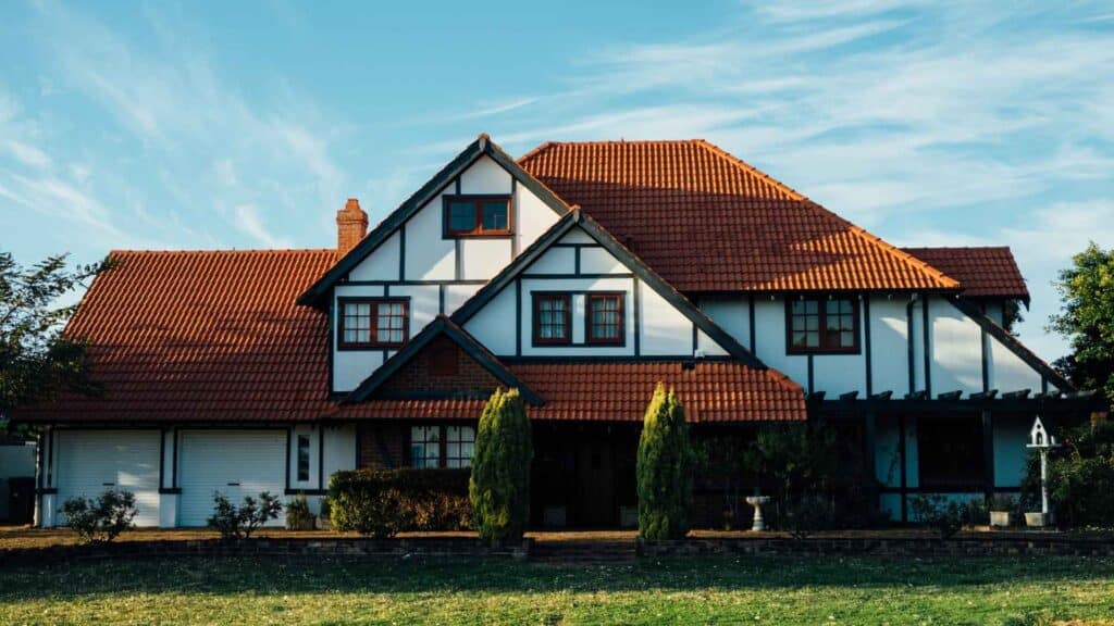 Two-story house with white walls, dark trim, and a roof